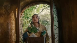 A woman standing in a doorway with a basket of plants featured in the Amazon Insurance Store ad 2023.