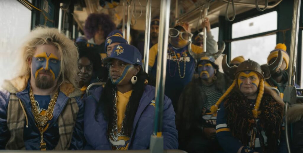 A group of people sitting on a bus in a DirecTV NFL Sunday ticket commercial.
