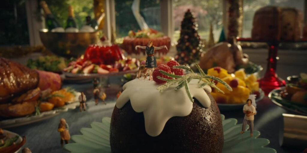 An ALDI Australia christmas pudding is sitting on a table in front of a spread of food.