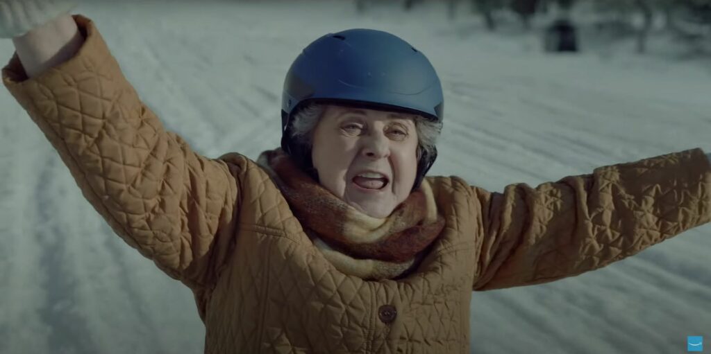A woman in a ski jacket with her arms outstretched stars in the captivating Amazon Christmas ad of 2023.