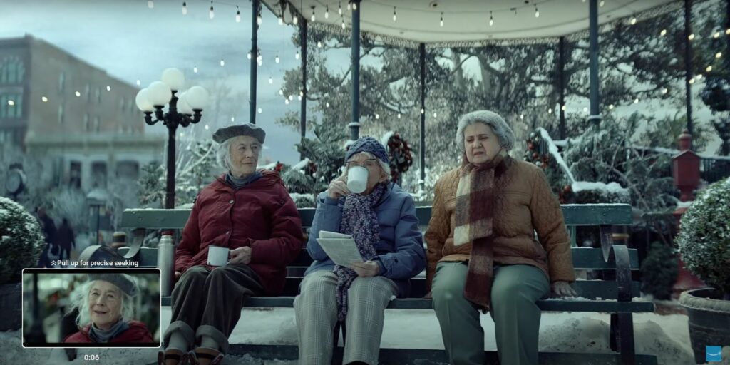 Three elderly women sitting on a bench in the snow, starring in an Amazon Christmas ad 2023.