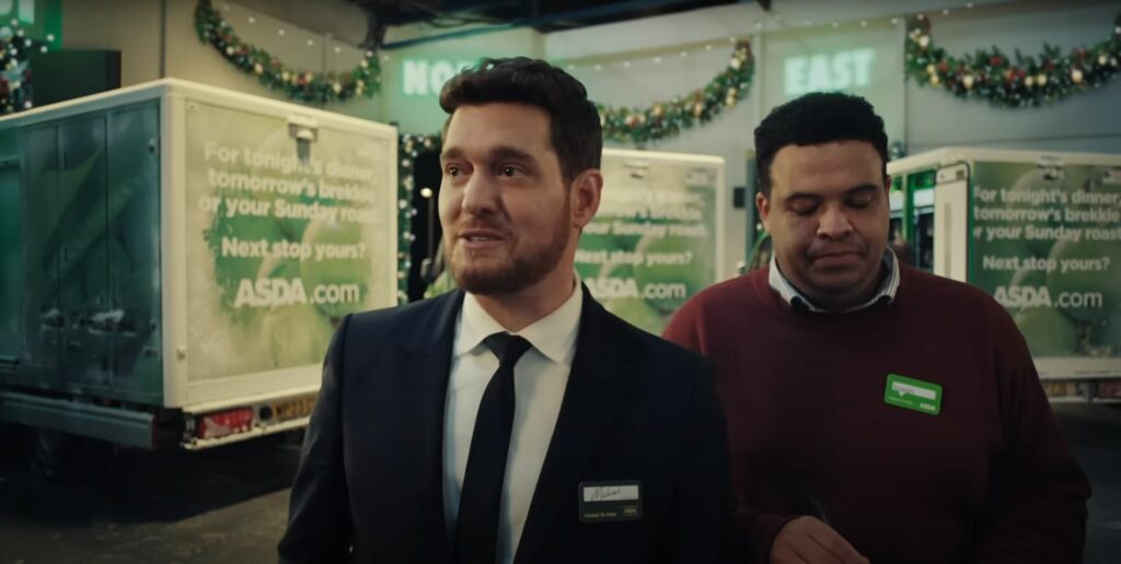 Two men standing next to each other in a warehouse during the Asda Christmas Commercial 2023.