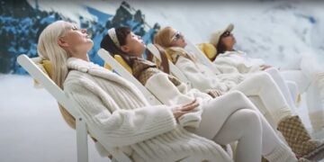 Four people in chic winter clothing, part of the 2024 Gucci Holiday Campaign, are reclining on chairs amidst a serene snowy landscape.
