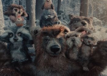 A group of animated forest animals, including a bear, raccoons, rabbits, and squirrels, pose together in a snowy, wooded environment inspired by the whimsical spirit of the Apple Holiday Ad 2025.