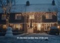 A person hangs upside down from rooftop Christmas lights on a snowy evening outside a decorated house, with a snowman in the yard and the caption, "It’s the most terrible time of the year." Is this holiday controversy or just another McDonald’s AI Christmas Ad?.