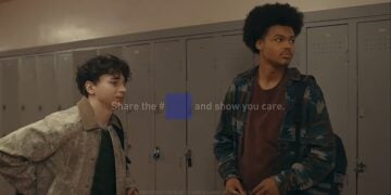 Two students stand in front of school lockers. Text overlay reads: "Share the #___ and show you care." The message is partially obscured by a blue square, hinting at a Blue Square Fumble moment inspired by the cultural fallout after Super Bowl LX.