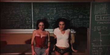 Two women pose in front of a large chalkboard filled with complex mathematical and scientific equations, brainstorming ideas for a potential Super Bowl 2026 advert featuring Poppi.